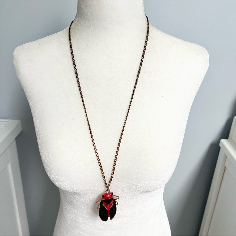 Cicada pendant necklace on a gold tone chain
